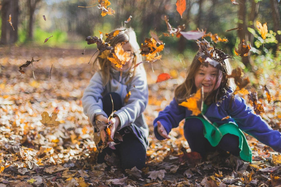 girls playing with leaves